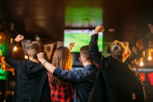 Freunde schauen Fußball in einer Sky-Sportsbar.